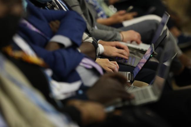 Delegates take notes during a session