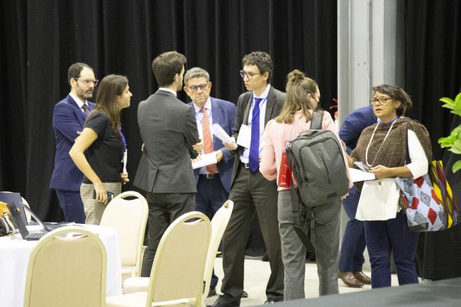 Delegates and secretariat huddle during the informal consultations