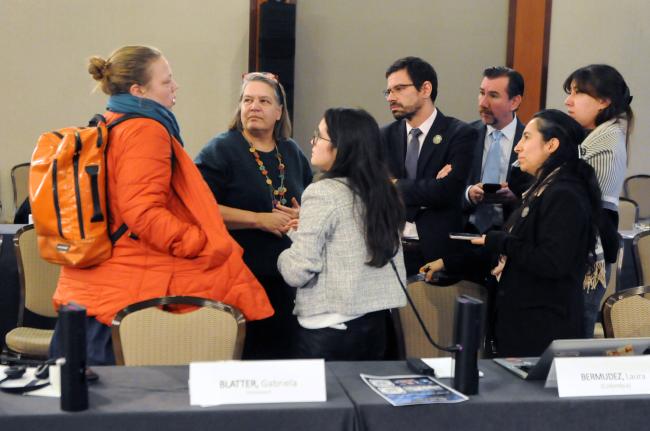 Delegates from Switzerland, Germany, Colombia, and Ecuador, confer during lunch time