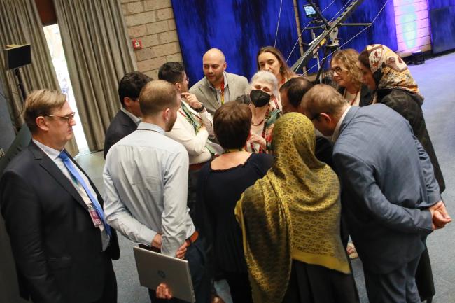 Delegates from the US, Canada, EU, Saudi Arabia, Iran and Cuba, and the Secretariat conferring in the sidelines